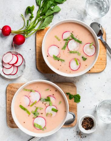Rosa Radieschensuppe mit Radieschenscheiben in einer Schüssel.