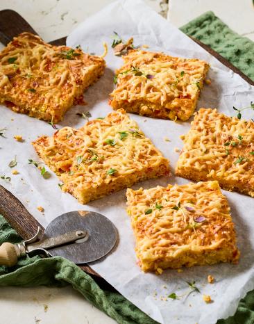 Schüttelpizza in Stücke geschnitten auf eine Brett.