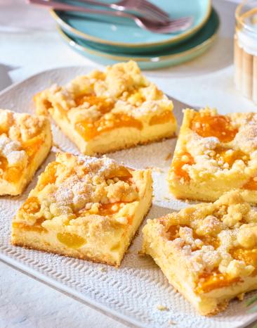 Aprikosenkuchen mit Streuseln vom Blech in Stücke geschnitten.