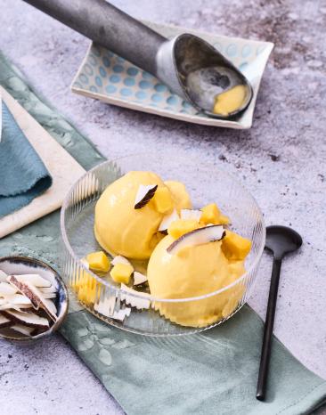 Mango-Kokos-Eis in Kugeln in Glasschälchen.