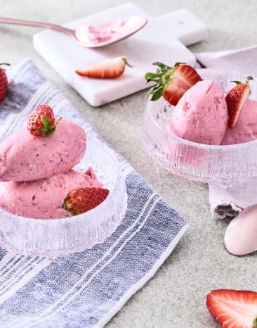 Hüttenkäse Eis mit Erdbeeren in Dessertschälchen mit frischen Erdbeeren