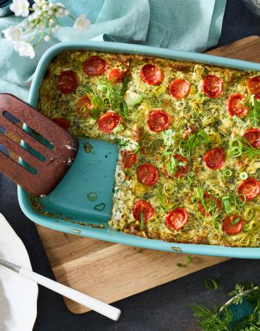 Gemüse Gratin mit Tomaten und Kräutern in einer Auflaufform.