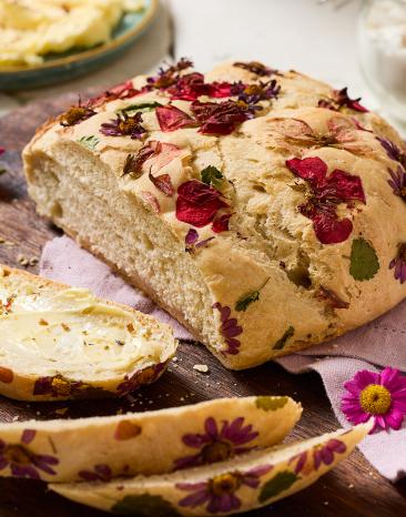Blütenbrot auf einem Brett, Scheiben abgeschnitten.