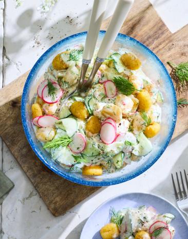 Gebackene Gnocchi mit Radieschen und Gurken in einer Salatschüssel.