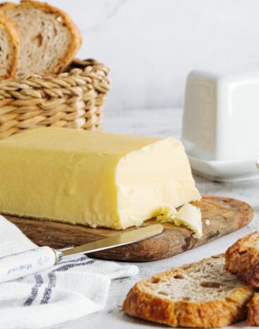 Butter selbstgemacht auf einem Brett mit frischem Brot.