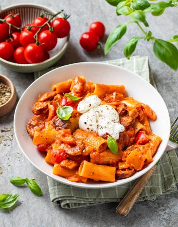 Cremige Pasta mit Chorizo und frischen Kirschtomaten in einem tiefen Teller.