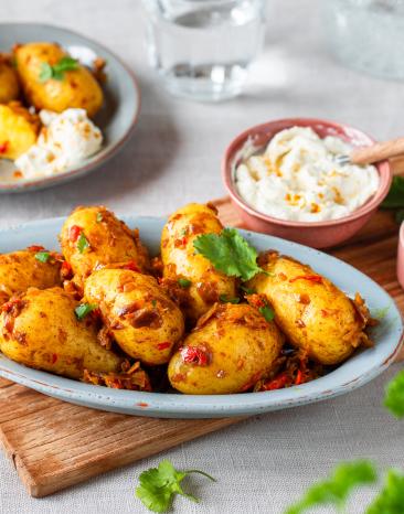 Fruchtige Bombay-Kartoffeln mit Gewürzen in Schüsseln.