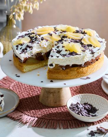 Birne-Helene-Torte auf einer Tortenplatte, angeschnitten.