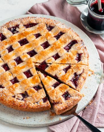 Linzer Torte angeschnitten auf einer Tortenplatte.