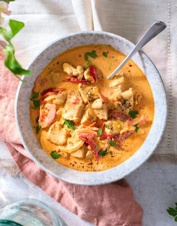 Geschnetzeltes mit Paprika in Senf-Sahne-Sauce in einer Schüssel.