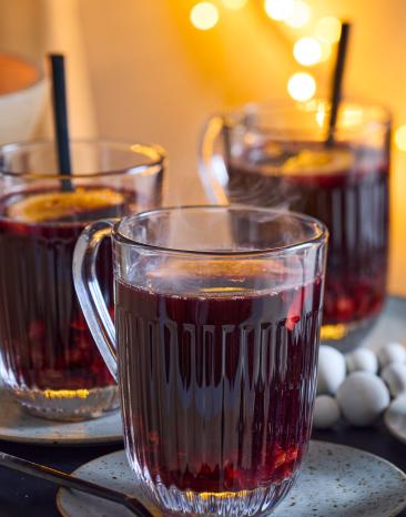 Glögg mit Orangenscheiben in Glastassen.