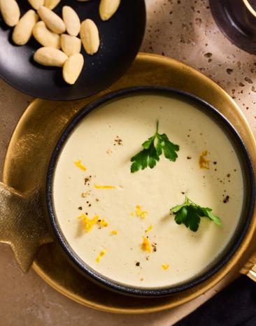 Mandelcremesuppe mit Petersilie und Zitronenschale garniert.