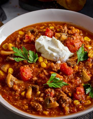Silvestersuppe mit Hackfleisch in einem tiefen Teller.