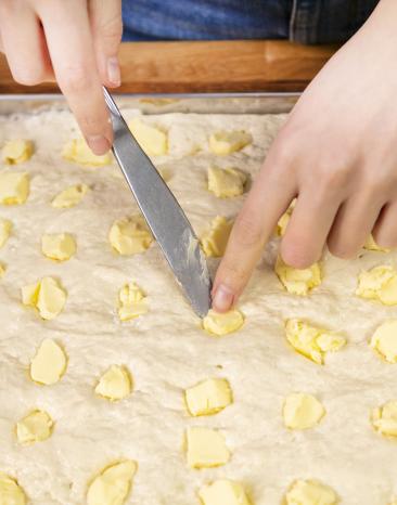 Butterflocken in die Teiglöcher geben.