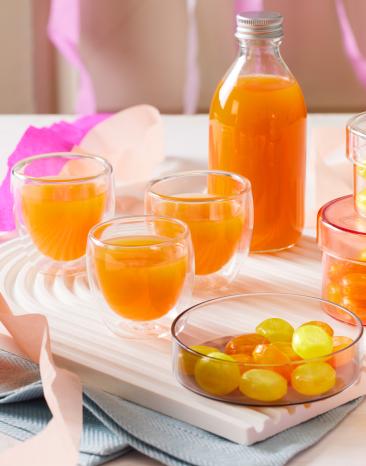 Fruchtbonbon-Likör in Flaschen und kleinen Gläsern.