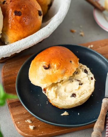 Rosinenbrötchen aufgeschnitten auf einem Frühstücksteller.