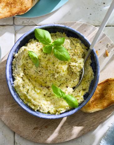 Artischocken Dip mit Basilikum und Baguette.