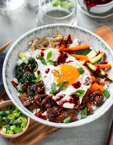 Bibimbap mit Spiegelei und Frühlingszwiebeln getoppt.