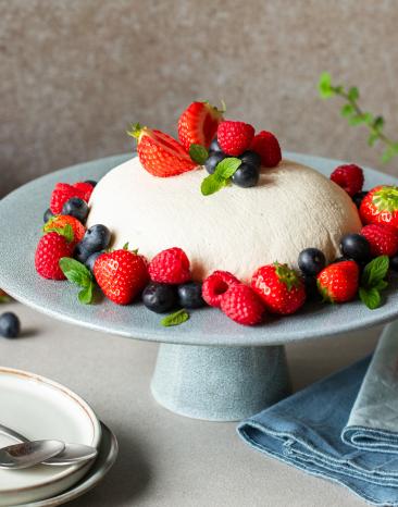 Joghurtbombe mit frischen Beeren garniert.