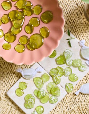 Grüne Salbeibonbons in einer rosa Schale.