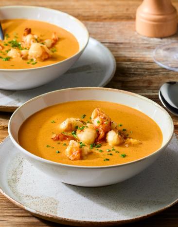 Französische Krustentiersuppe in Suppentellern.