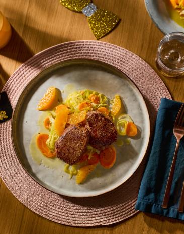 Gebratene Hirschmedaillons mit Lauch-Karotten-Gemüse in Orangensud